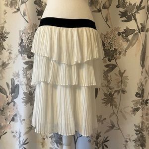 White layered pleated skirt with black stretchy waistband.
